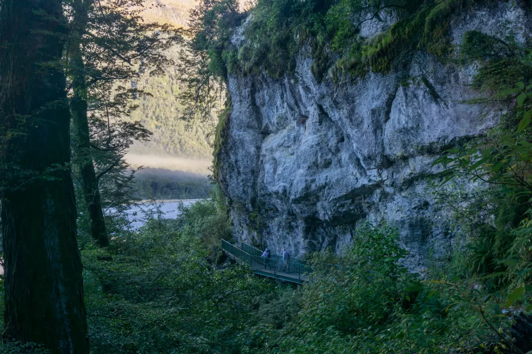 Person walking by a cliff on the Dart Track