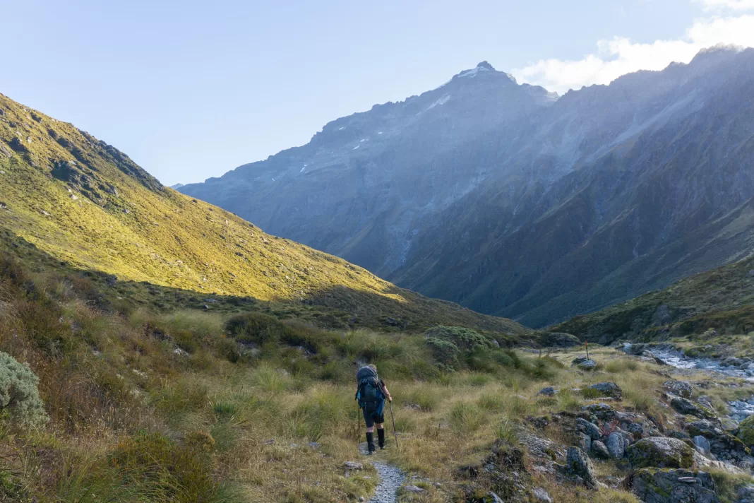 Tramper walking along the Rees Dart Track at sunset