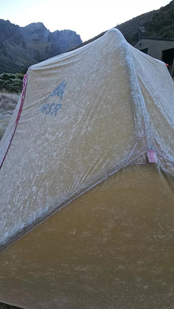 MSR tent covered in white frost with mountains in the background
